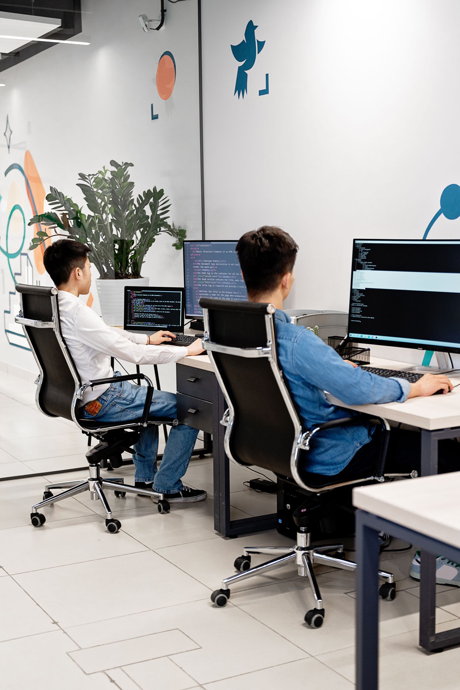 Engineers reviewing technical work together at computer monitors